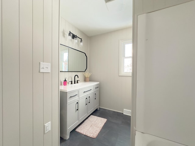 bathroom featuring vanity and wood walls