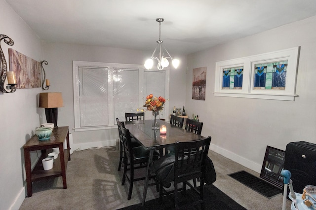 dining area with carpet and an inviting chandelier