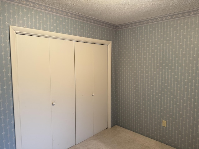 unfurnished bedroom with a textured ceiling and light carpet