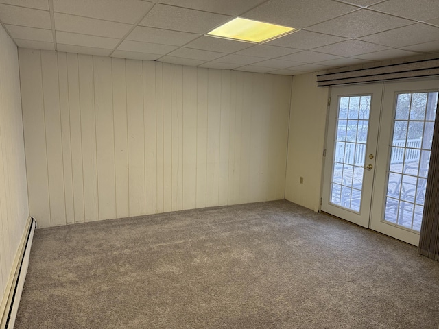 unfurnished room featuring a paneled ceiling, french doors, a baseboard radiator, and carpet