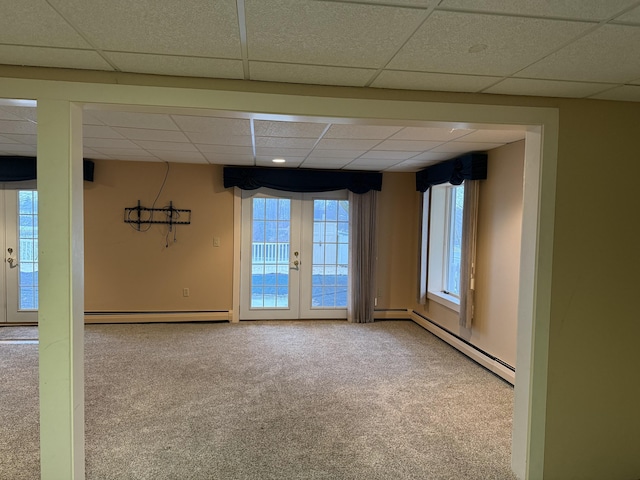 unfurnished room featuring a baseboard heating unit, french doors, and carpet flooring