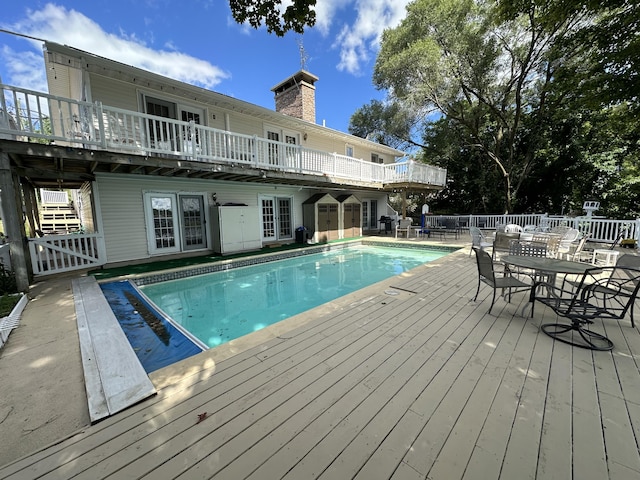 view of swimming pool featuring french doors and a wooden deck