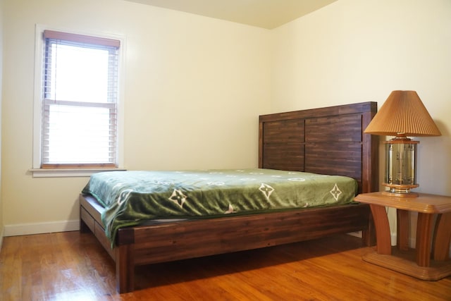 bedroom with multiple windows and hardwood / wood-style floors