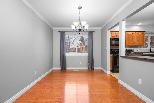 unfurnished dining area with crown molding, sink, plenty of natural light, and a notable chandelier