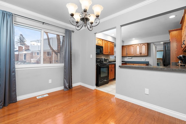 kitchen featuring a chandelier, light wood-type flooring, crown molding, and black appliances