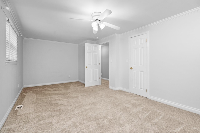 unfurnished bedroom featuring light carpet, ceiling fan, and crown molding