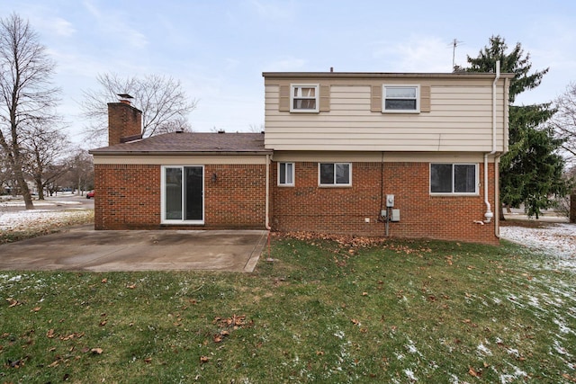 back of property with a yard and a patio