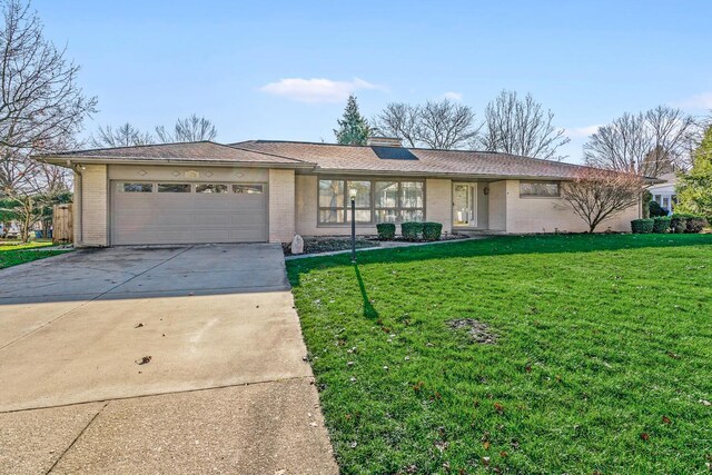 ranch-style home featuring a garage and a front lawn