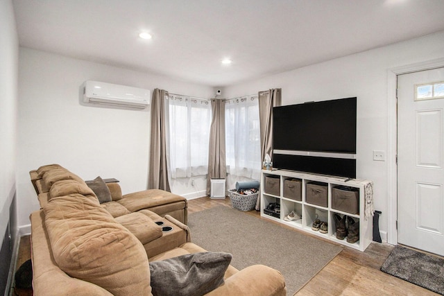 living room with hardwood / wood-style floors and an AC wall unit