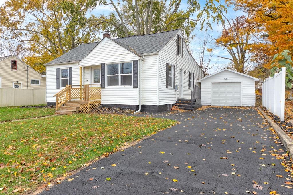 view of front facade with a front yard, a garage, and an outdoor structure