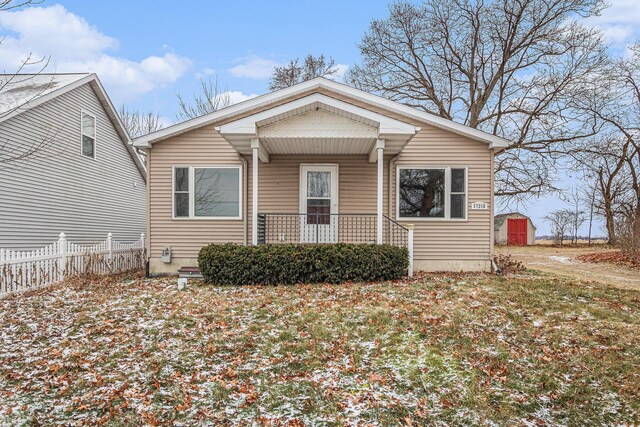 bungalow with a front yard and a storage unit