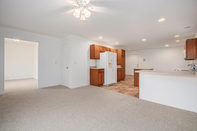 kitchen featuring light carpet, kitchen peninsula, ceiling fan, sink, and white refrigerator with ice dispenser