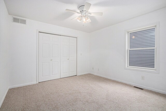 unfurnished bedroom with carpet flooring, ceiling fan, and a closet