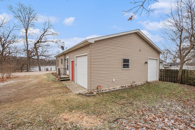 view of side of property featuring a water view, a garage, and an outdoor structure