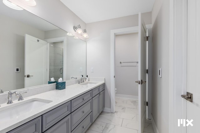 full bathroom featuring toilet, marble finish floor, a shower stall, and a sink