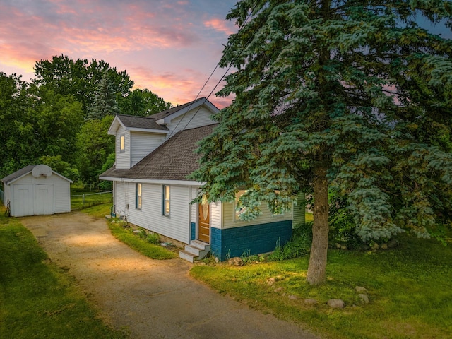 property exterior at dusk featuring a lawn and a shed