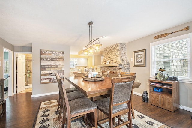 dining space with a notable chandelier, dark hardwood / wood-style floors, and a fireplace