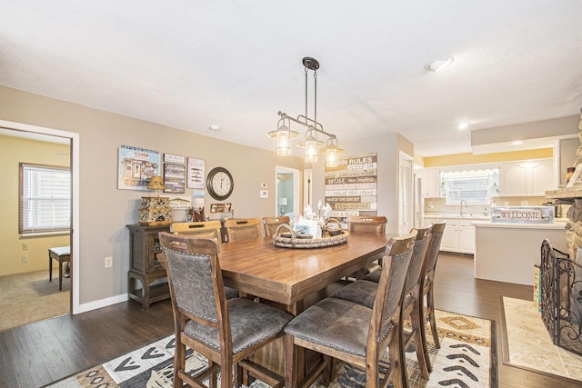 dining room featuring sink, a healthy amount of sunlight, and dark hardwood / wood-style floors