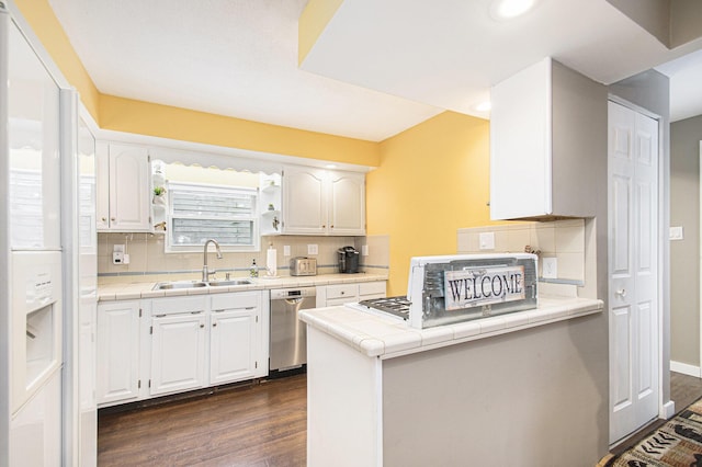 kitchen with tasteful backsplash, sink, dishwasher, white cabinetry, and tile counters