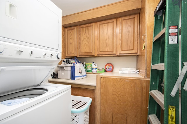 laundry room featuring cabinets and stacked washer and dryer