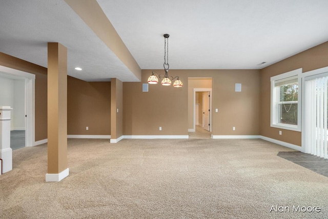 unfurnished room featuring light colored carpet and a chandelier