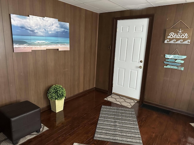 entrance foyer with dark hardwood / wood-style floors and wood walls