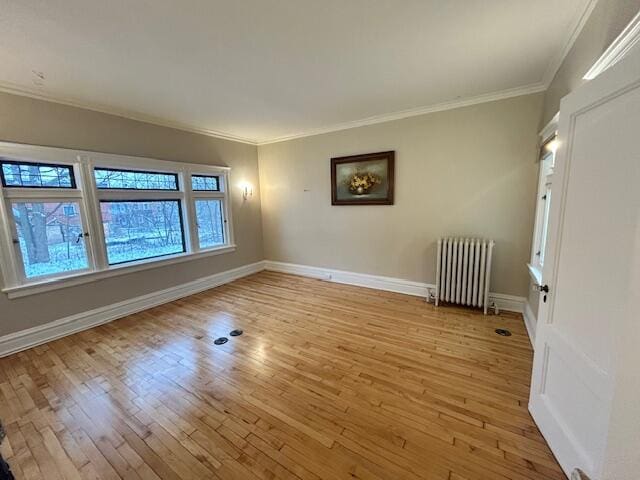 unfurnished room with radiator heating unit, light hardwood / wood-style floors, and crown molding