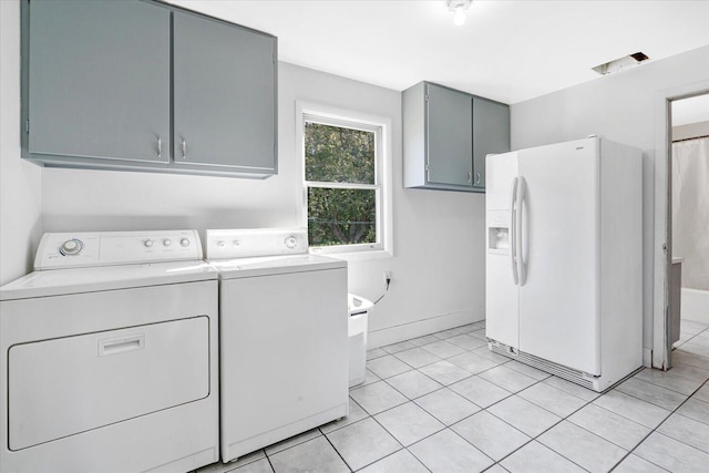 washroom with cabinets, light tile patterned flooring, and washing machine and clothes dryer