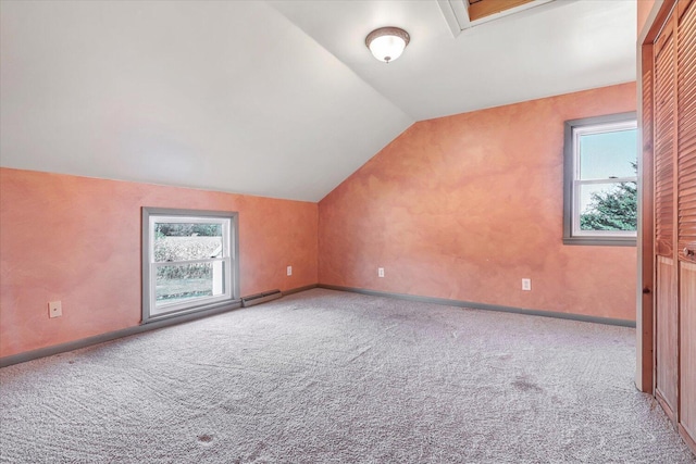 bonus room with carpet, a healthy amount of sunlight, lofted ceiling, and a baseboard heating unit