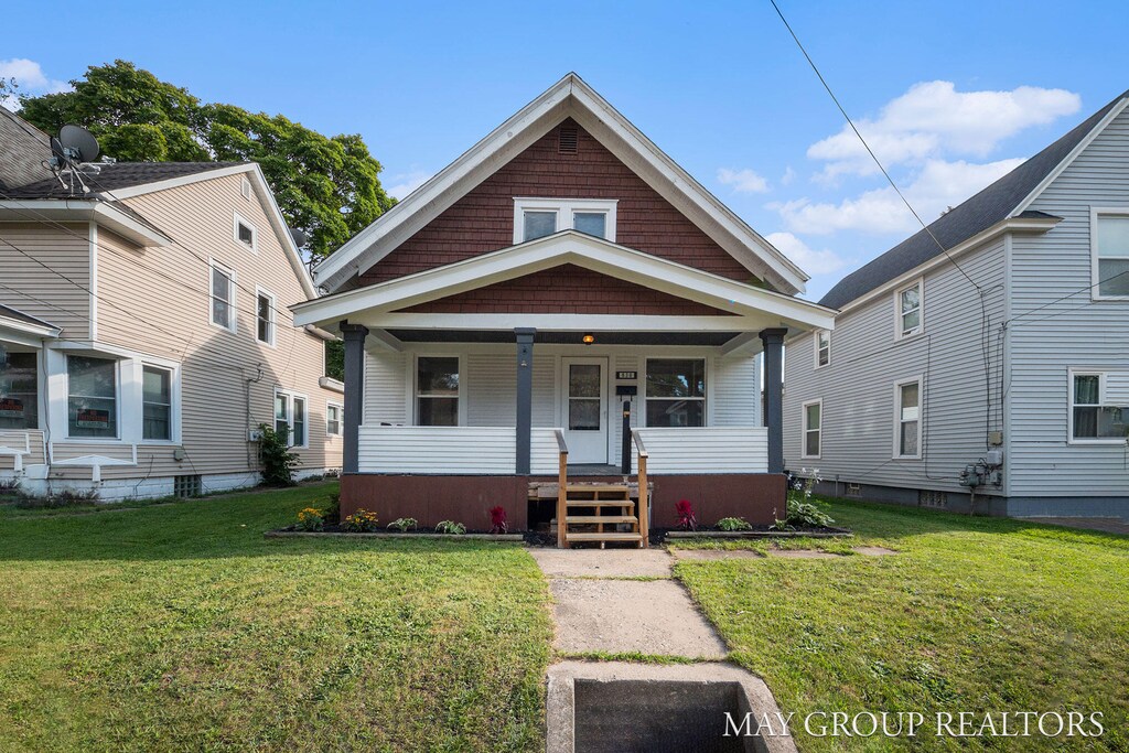 bungalow-style house featuring a porch and a front lawn