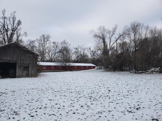 yard layered in snow featuring an outbuilding