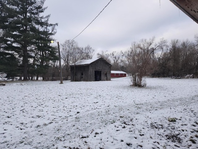 yard layered in snow featuring an outbuilding