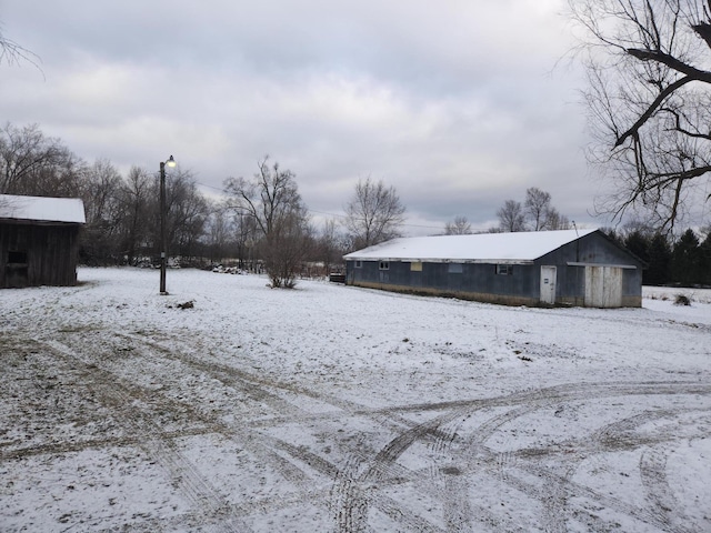 yard layered in snow featuring an outbuilding