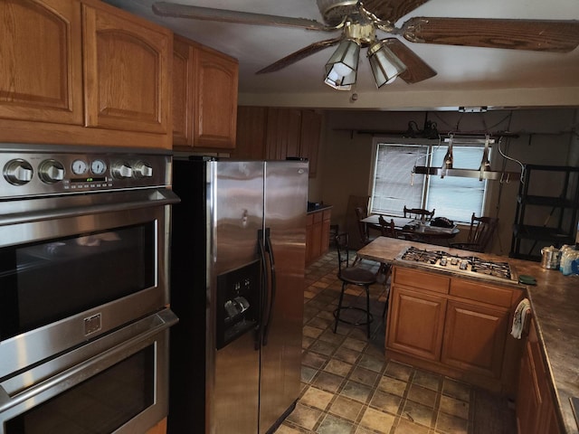 kitchen with ceiling fan and appliances with stainless steel finishes