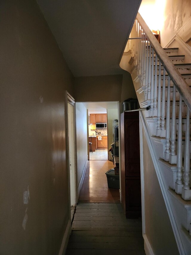 corridor with hardwood / wood-style flooring