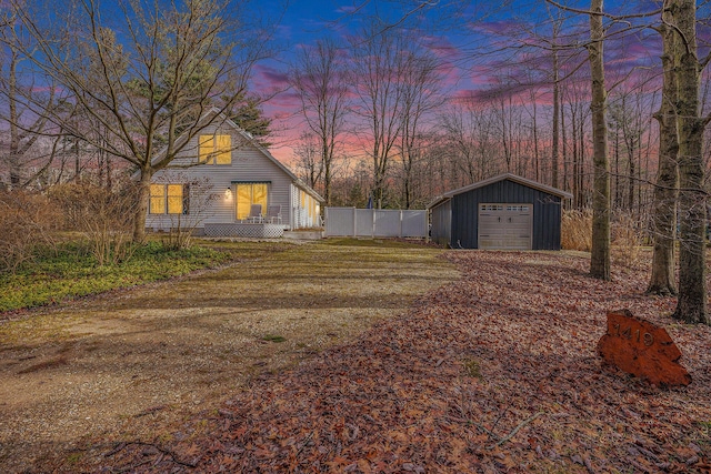 yard at dusk featuring an outbuilding and a garage