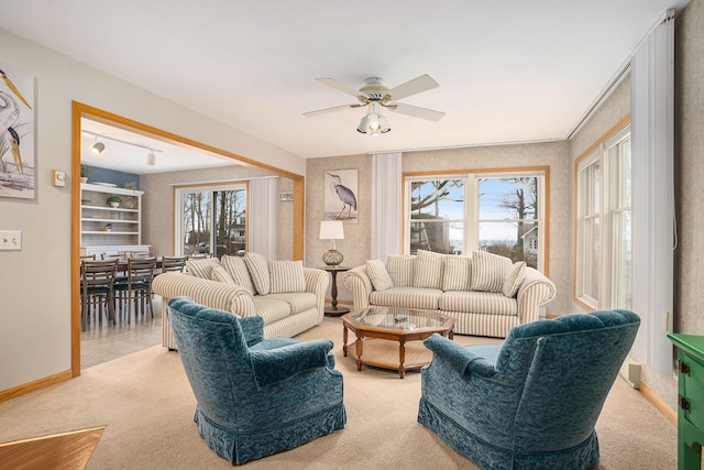 living room with ceiling fan, plenty of natural light, and light carpet