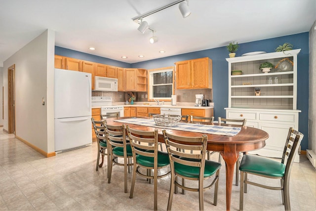 kitchen with tasteful backsplash, light brown cabinetry, sink, and white appliances