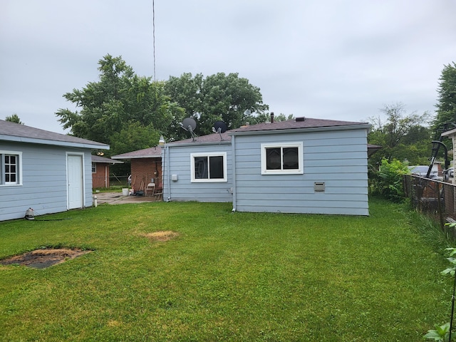 rear view of property featuring a lawn