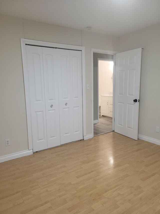 unfurnished bedroom with light wood-type flooring and a closet