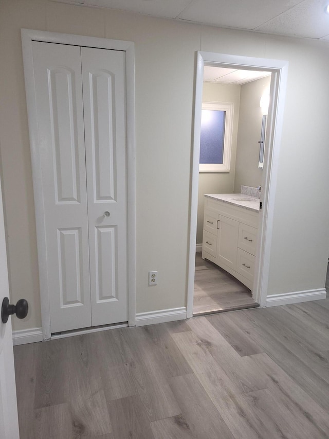 unfurnished bedroom featuring light wood-type flooring, sink, and a closet