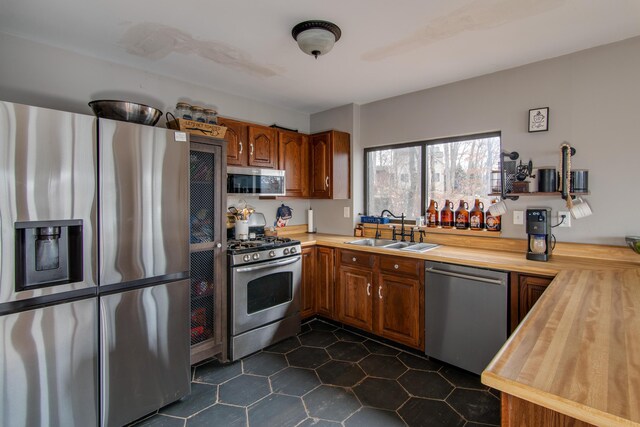 kitchen with butcher block counters, sink, and stainless steel appliances