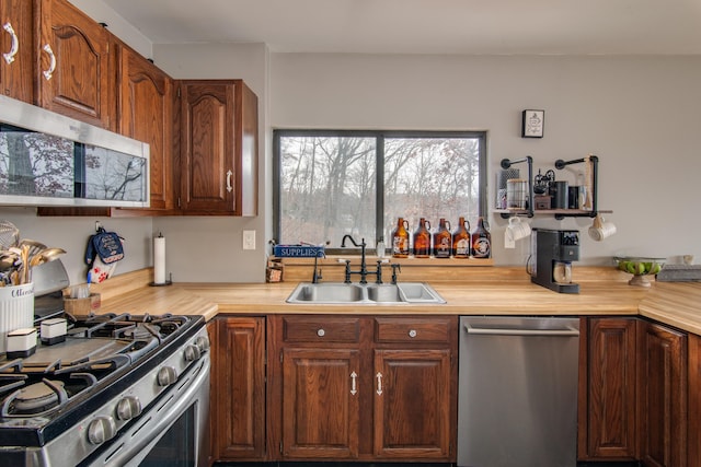 kitchen featuring sink, wooden counters, and appliances with stainless steel finishes