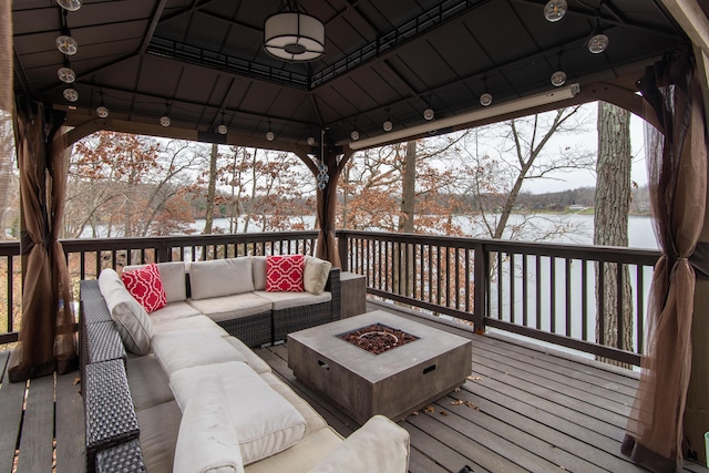 snow covered deck featuring a gazebo and an outdoor living space with a fire pit