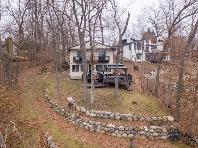 back of property featuring a gazebo, a wooden deck, and a yard