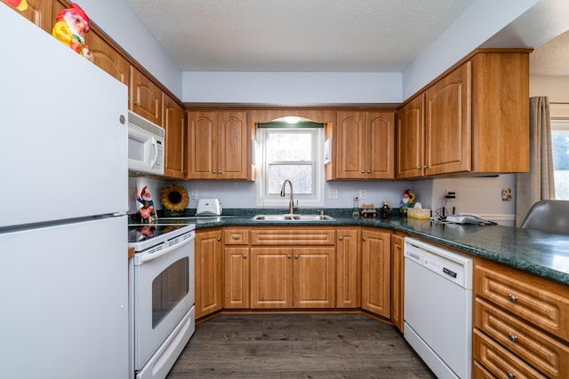 kitchen featuring a textured ceiling, white appliances, dark wood-type flooring, and sink