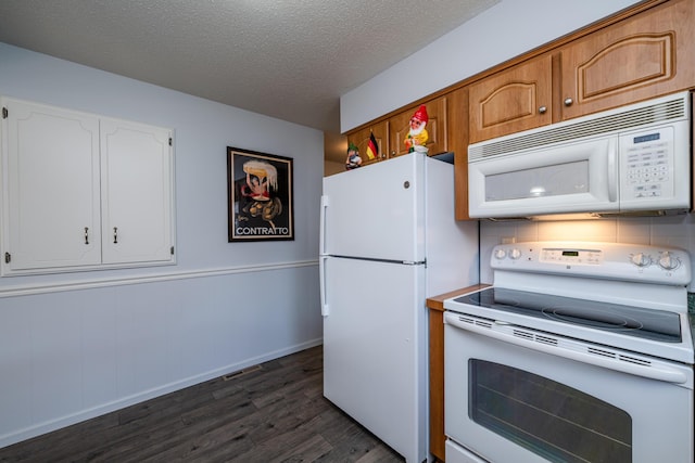 kitchen with a textured ceiling, dark hardwood / wood-style floors, and white appliances