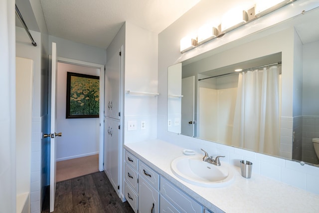 bathroom featuring vanity, toilet, wood-type flooring, and a textured ceiling