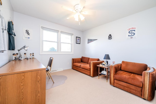 carpeted home office featuring ceiling fan