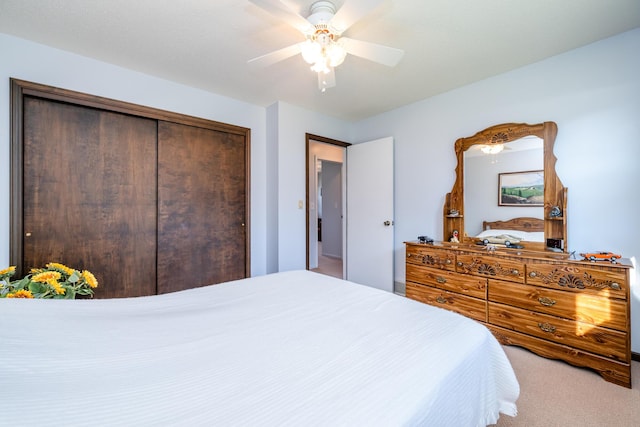 carpeted bedroom featuring ceiling fan and a closet